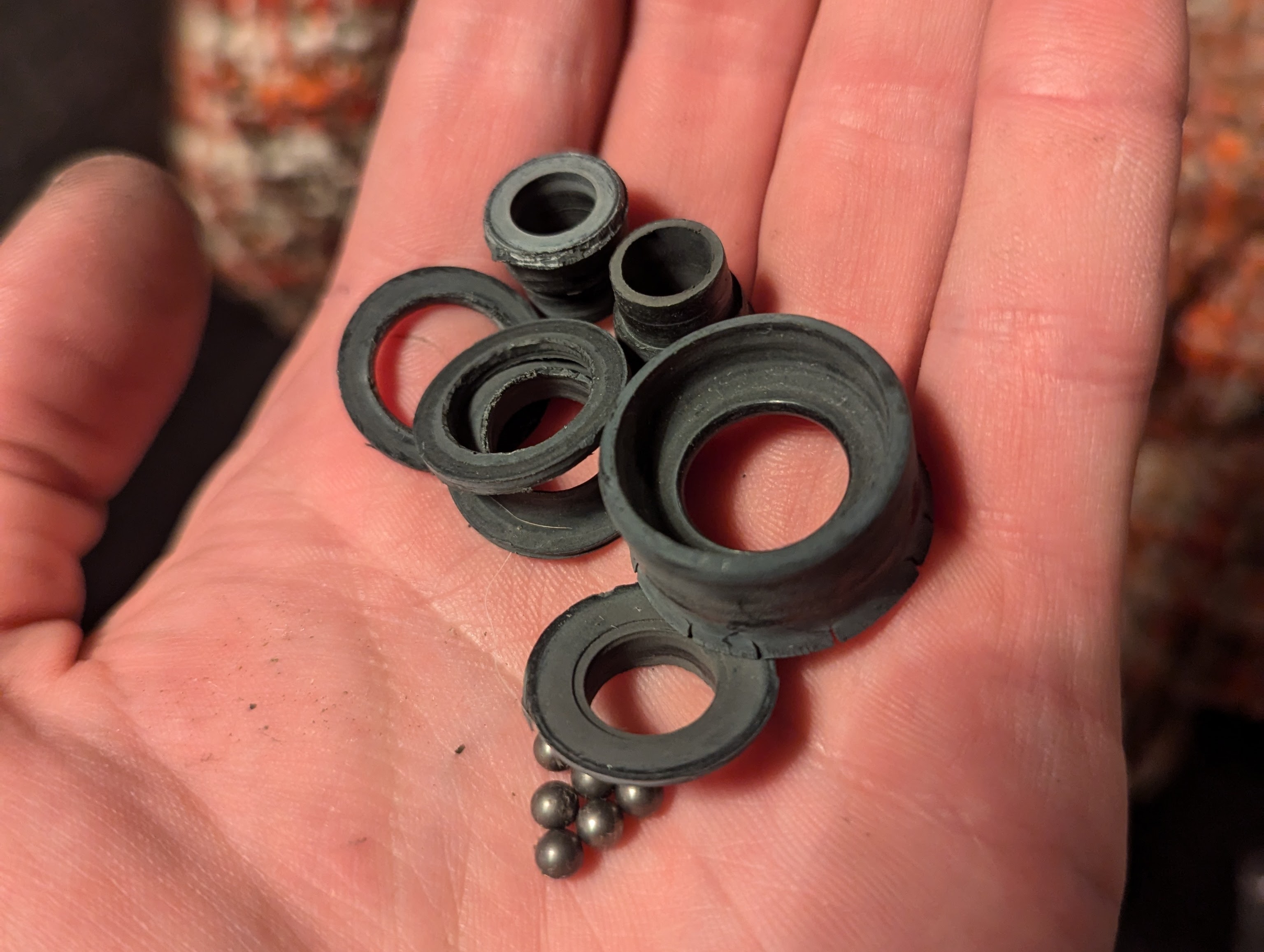 Pieces of a failed bearing including a broken plastic housing and several metal balls.