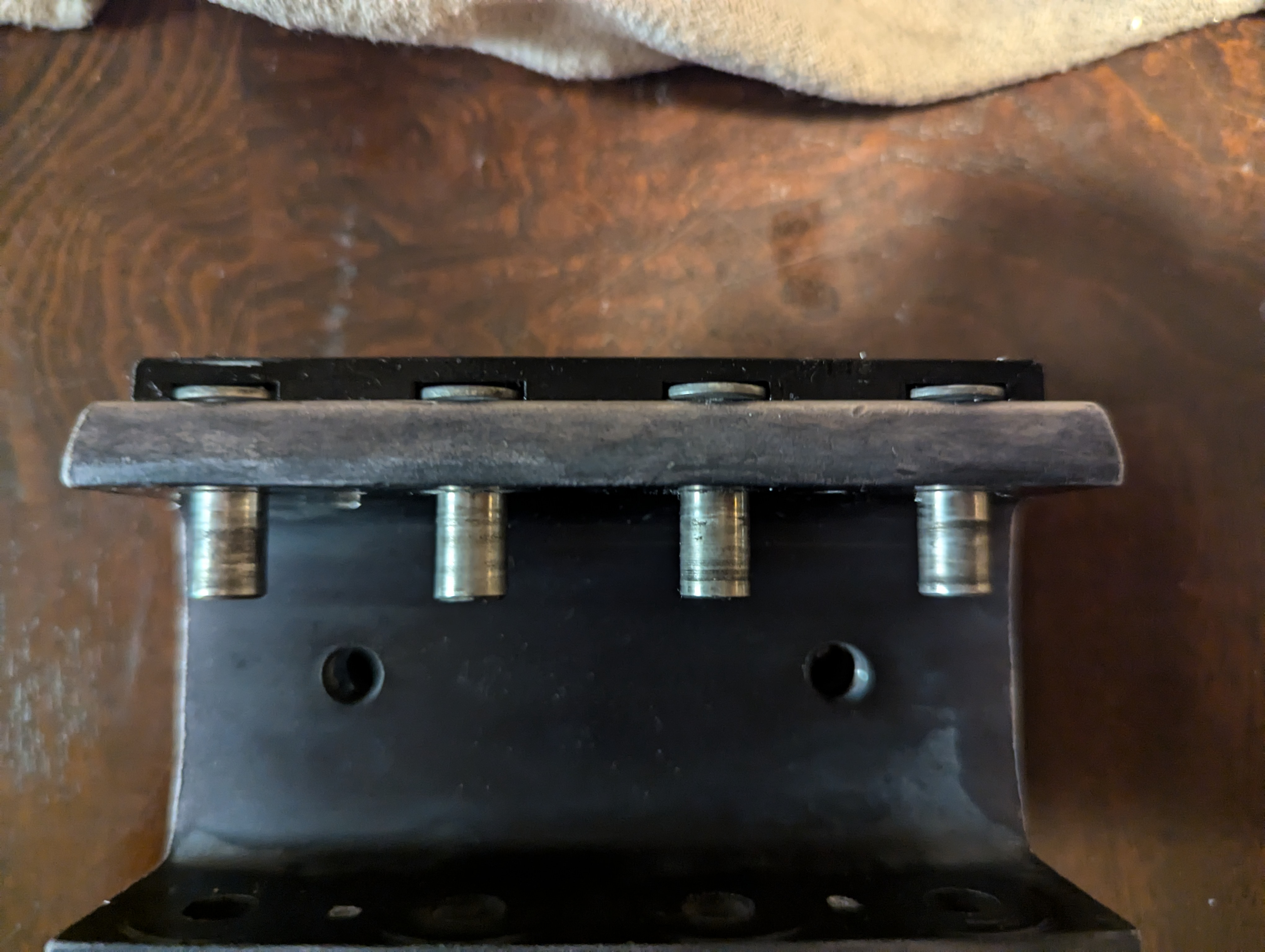 View of bottom of car showing four pins in reversed position, held in place by a black plastic cover piece on the exterior of the car.