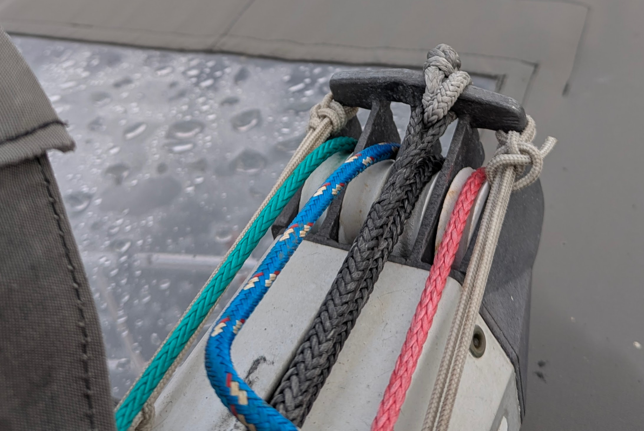 Top-down view of end of boom with three reef lines and the outhaul visible.